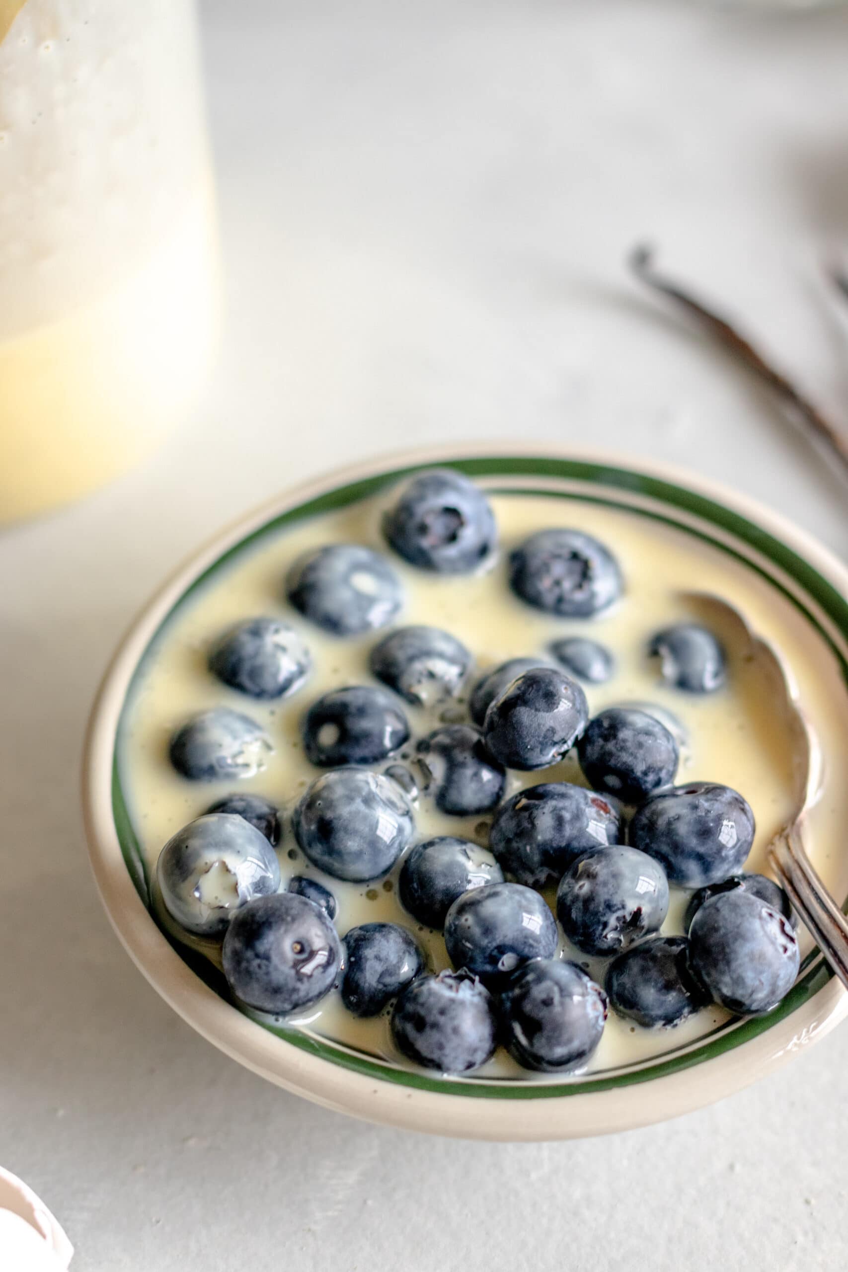 Vanilla custard sauce in a bowl with blueberries. 