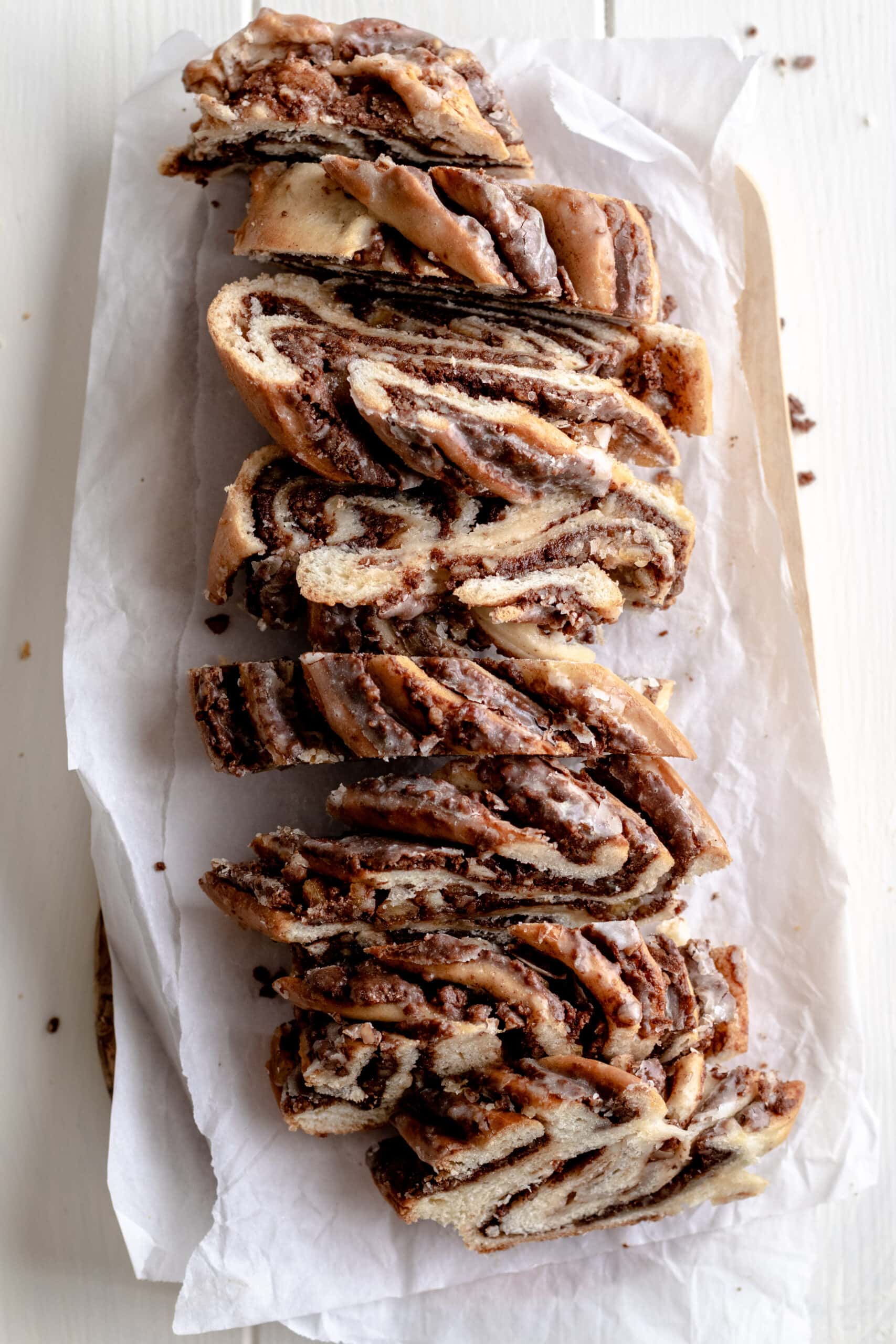 Image of chocolate nut swirl bread cut into slices on top of parchment paper.