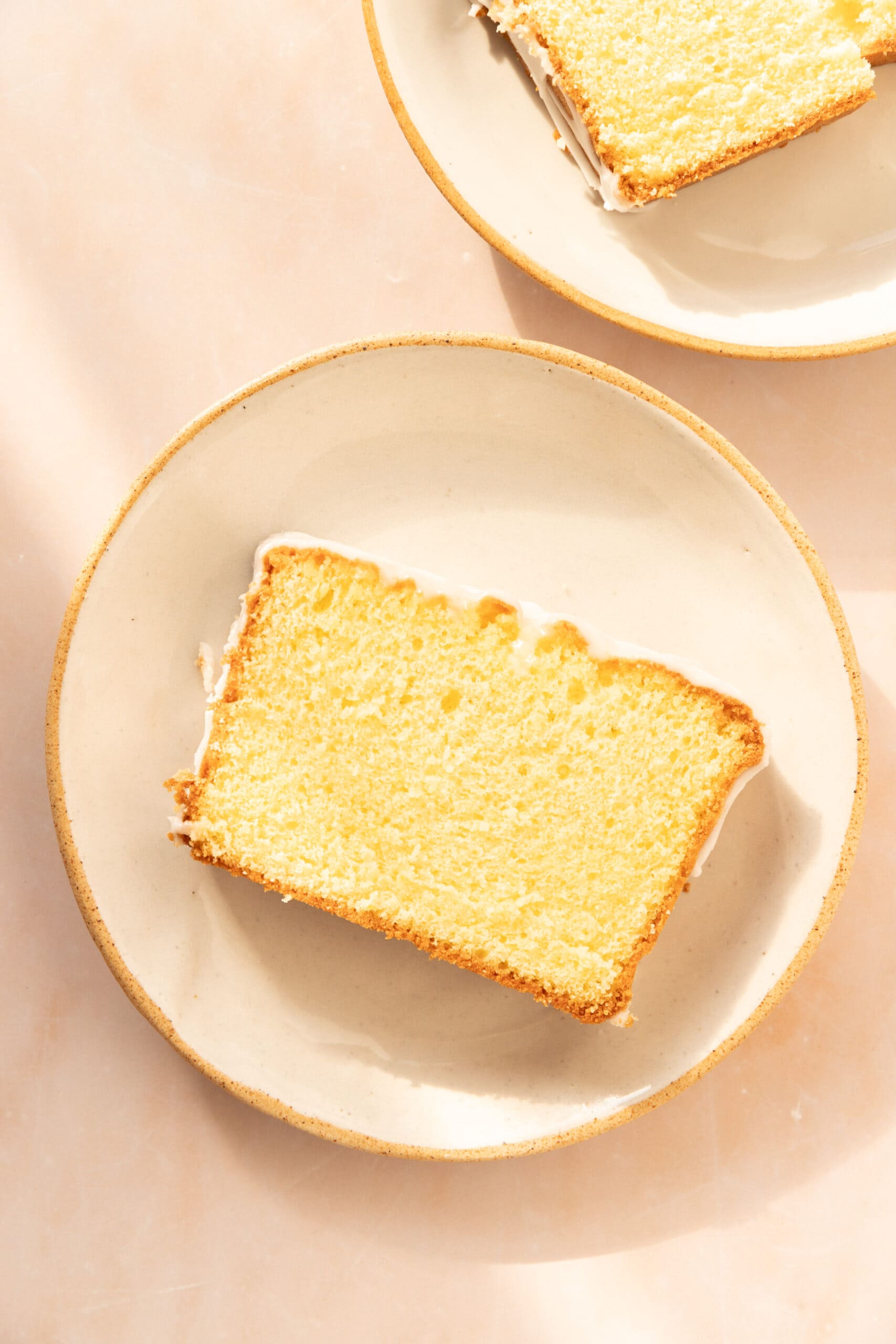 Slice of lemon loaf cake on a white plate. 