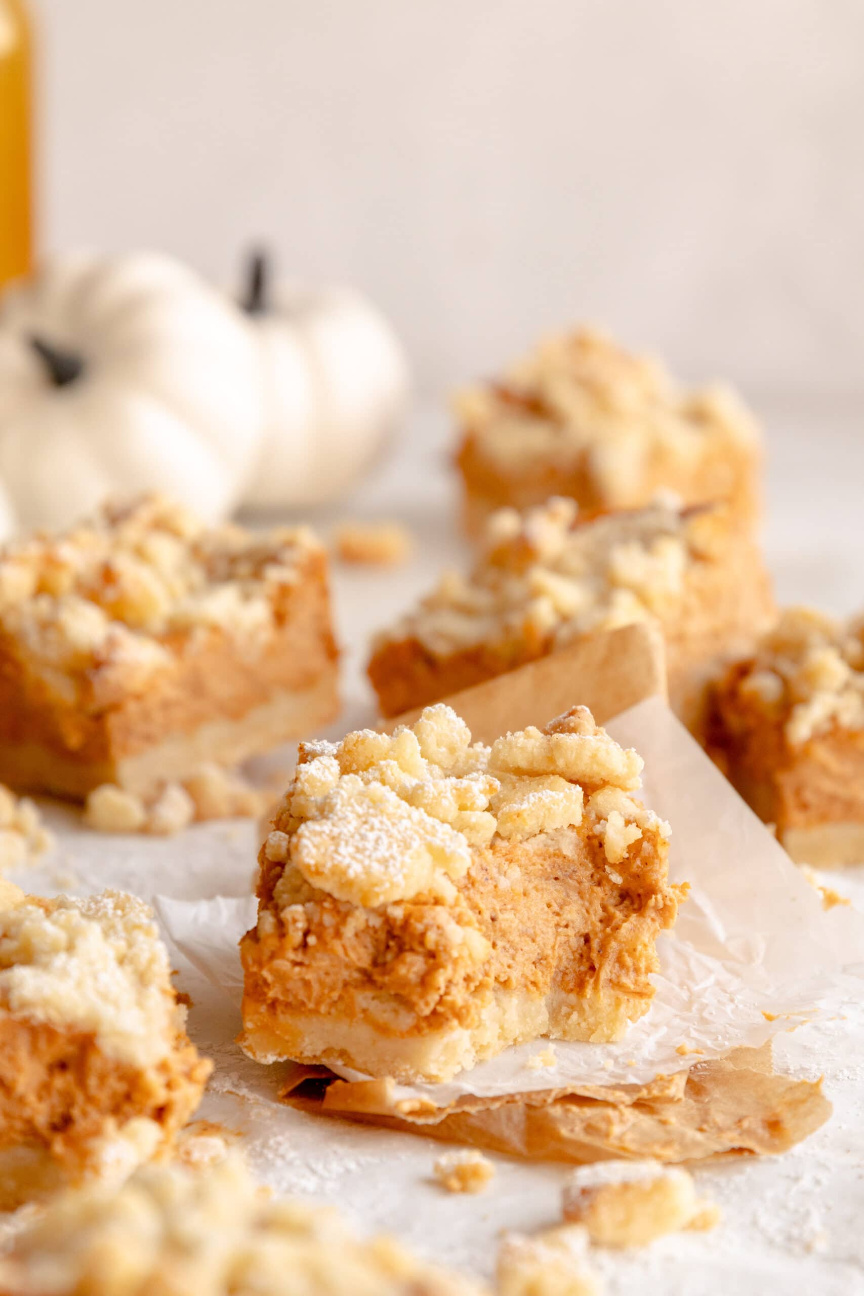 Side view of a streusel pumpkin pie bar with a bite taken out of the corner.