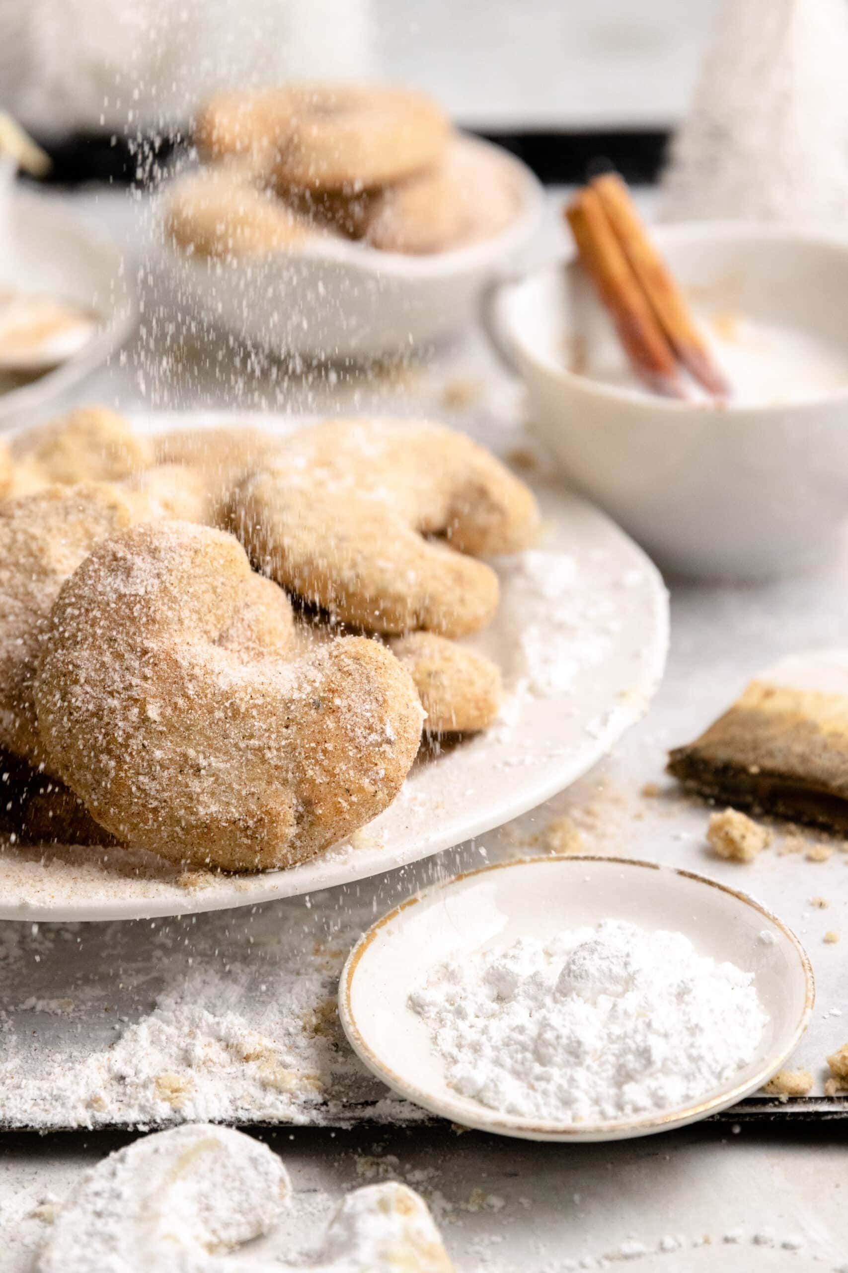 White plate on a parchment lined baking sheet with Cinnamon Sugar Coated Chai Kipferl Cookies.