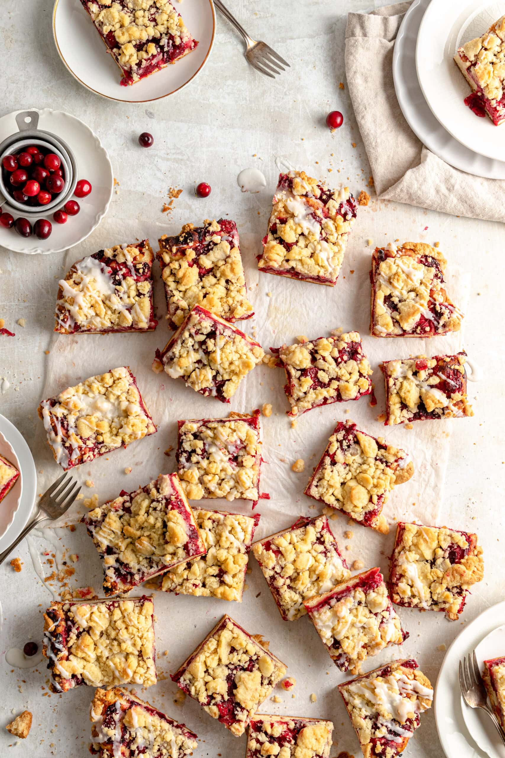 Overhead image of Cranberry Streuselkuchen cut into squares on parchment paper.