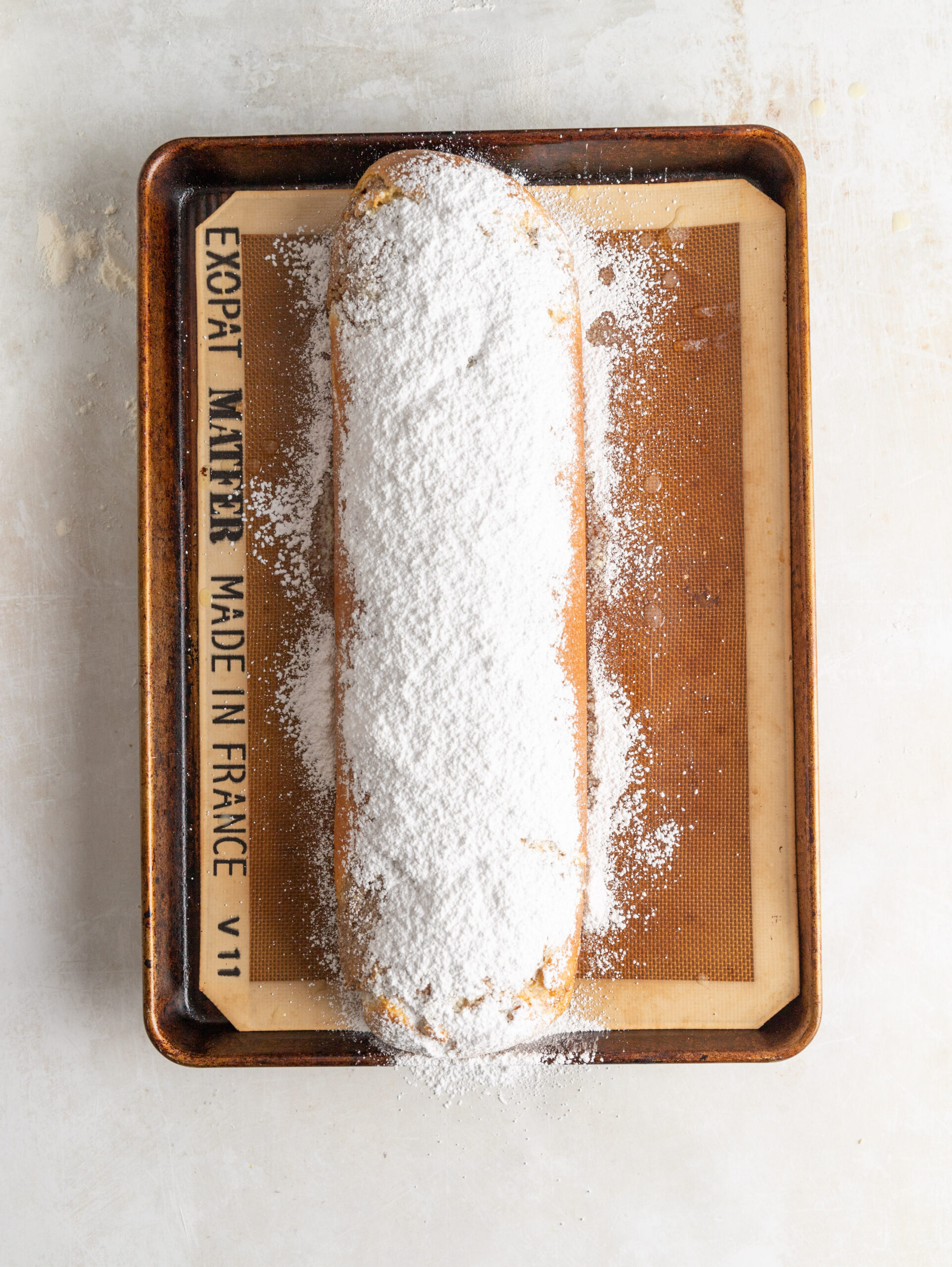 Overhead image of the nut strudel fully baked, brushed in butter, and topped with powdered sugar. 