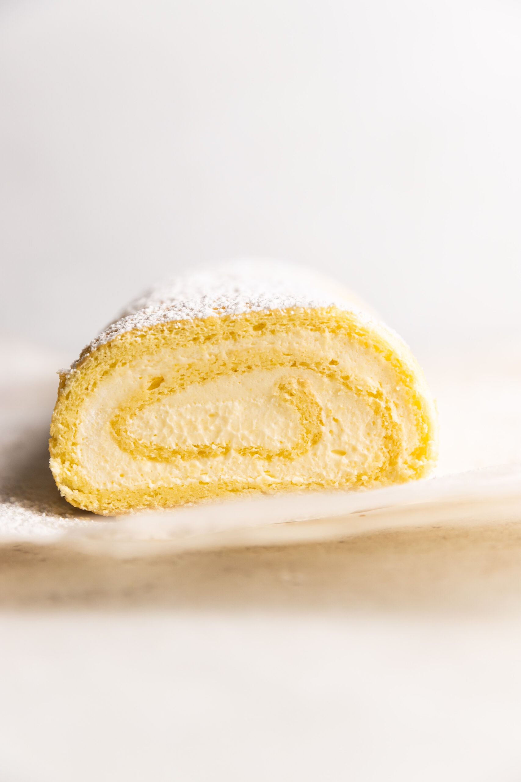 Cross section view of the Lemon Roulade cake with powdered sugar on top.