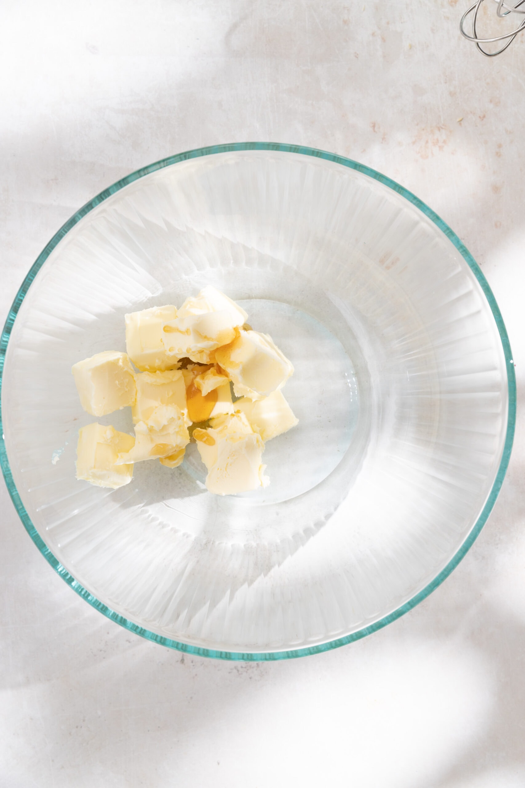 Cubed butter and honey in a large bowl, ready to be creamed. 