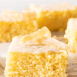Side view of a square slice of zitronenkuchen topped with candied lemon peel.