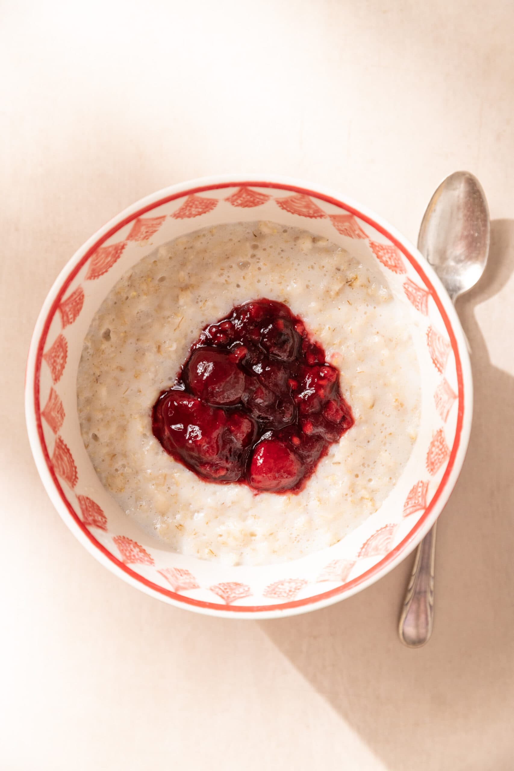 Bowl of oatmeal with berry compote on top.