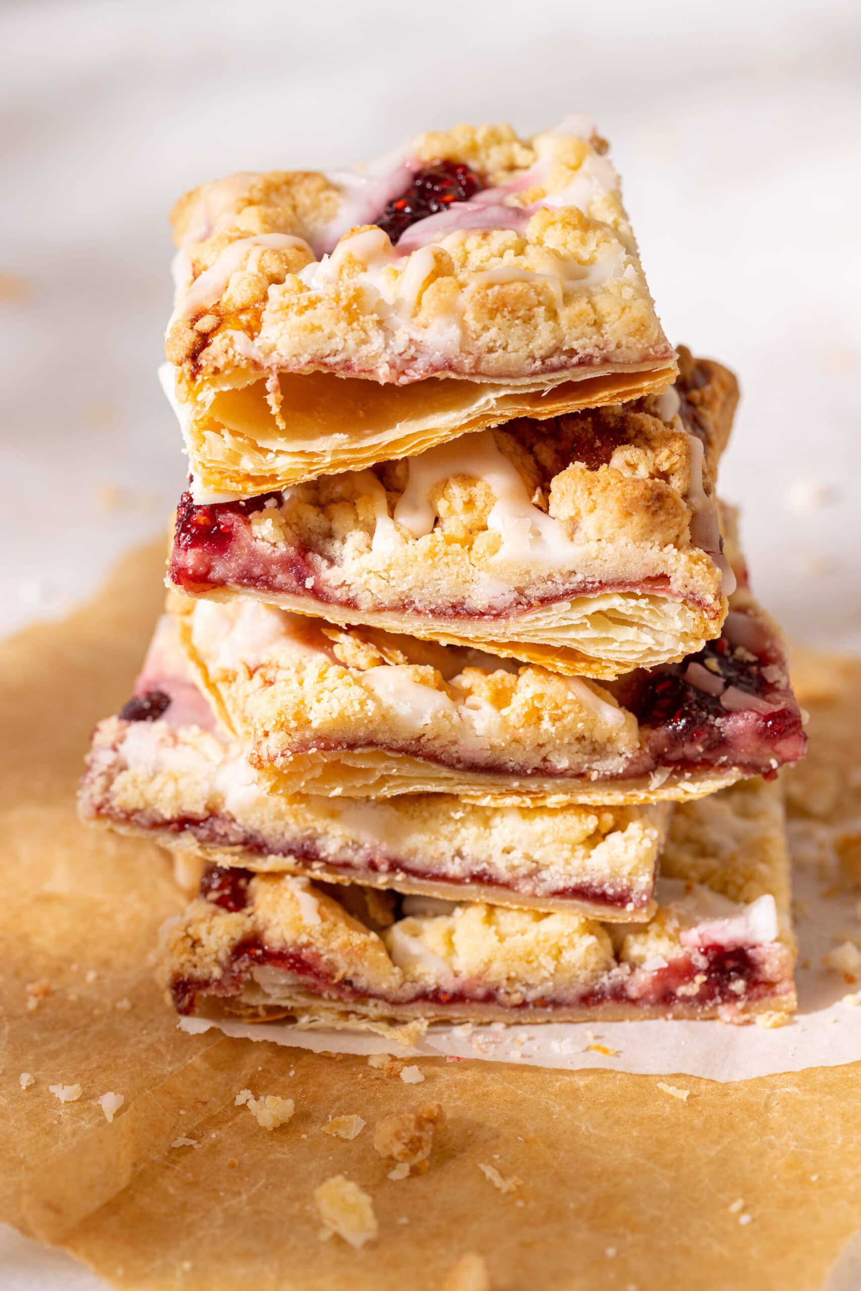 Side view stack of raspberry prasselkuchen with the layers of puff pastry visible. 