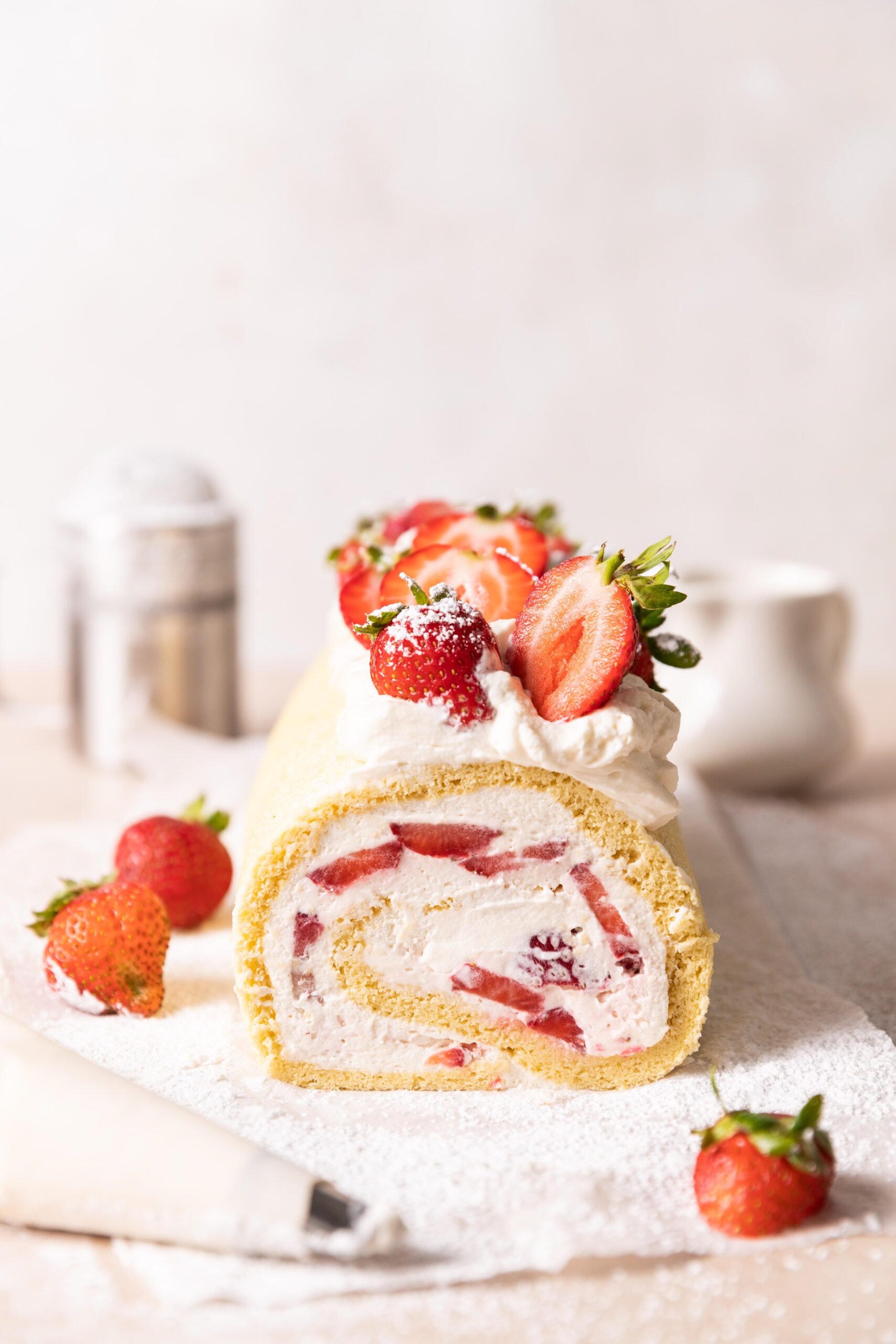 Side view of a Strawberry Swiss roll with the cake roll and filling visible. 