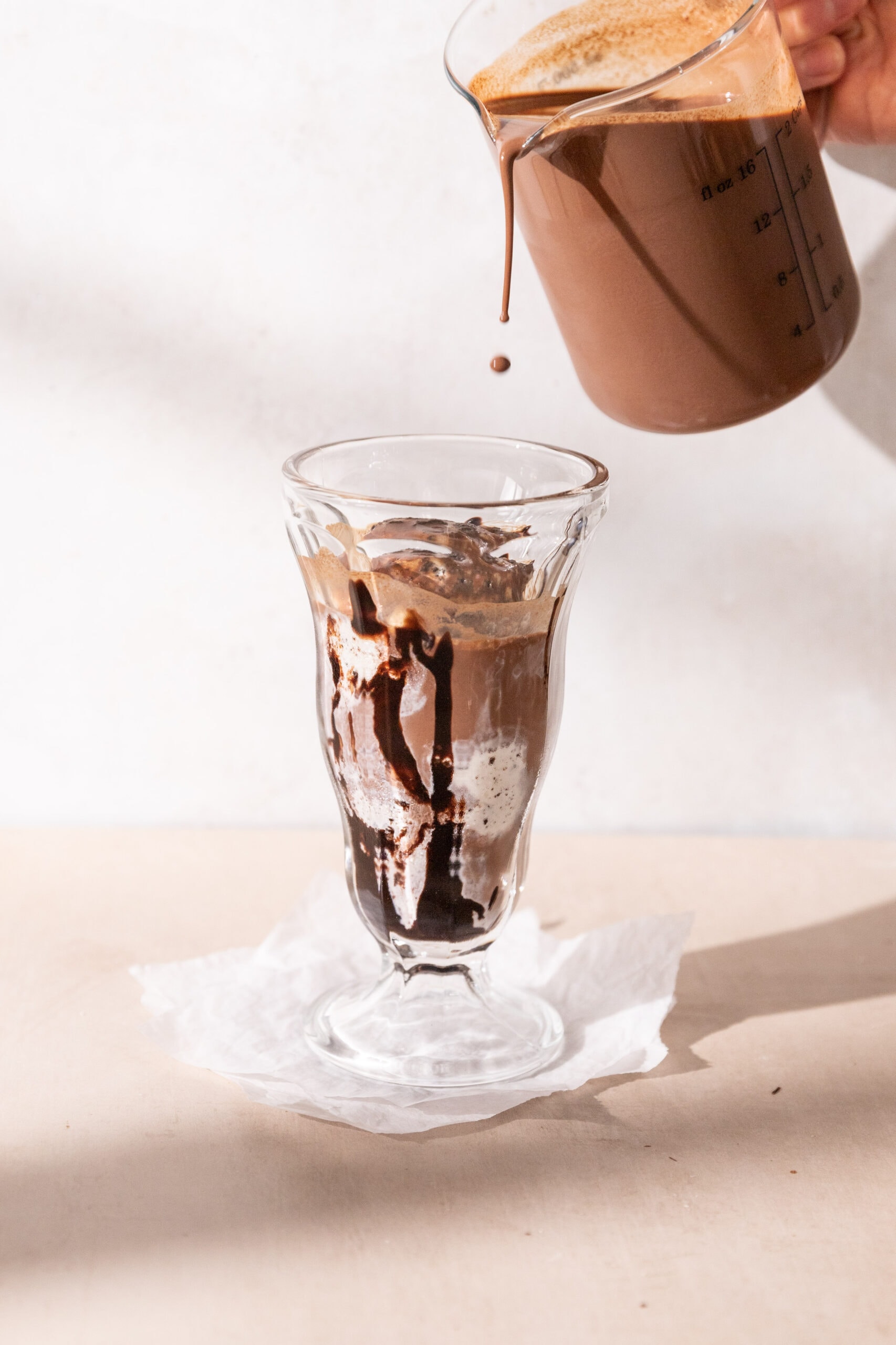 Eisschokolade being assembled in a milkshake glass. 