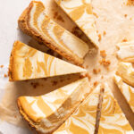 Overhead view of pumpkin swirl cheesecake cut into slices.