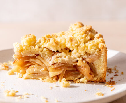 Side view of a thick slice of German Apple Pie with a streusel topping.