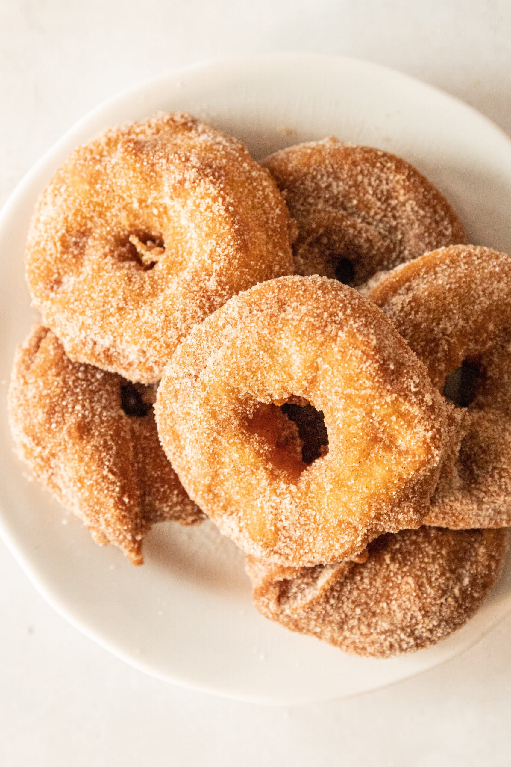 Overhead view of a stack of fried apple rings coated in cinnamon sugar. 