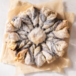 Chocolate Puff Pastry Snowflake on parchment paper dusted with powdered sugar.