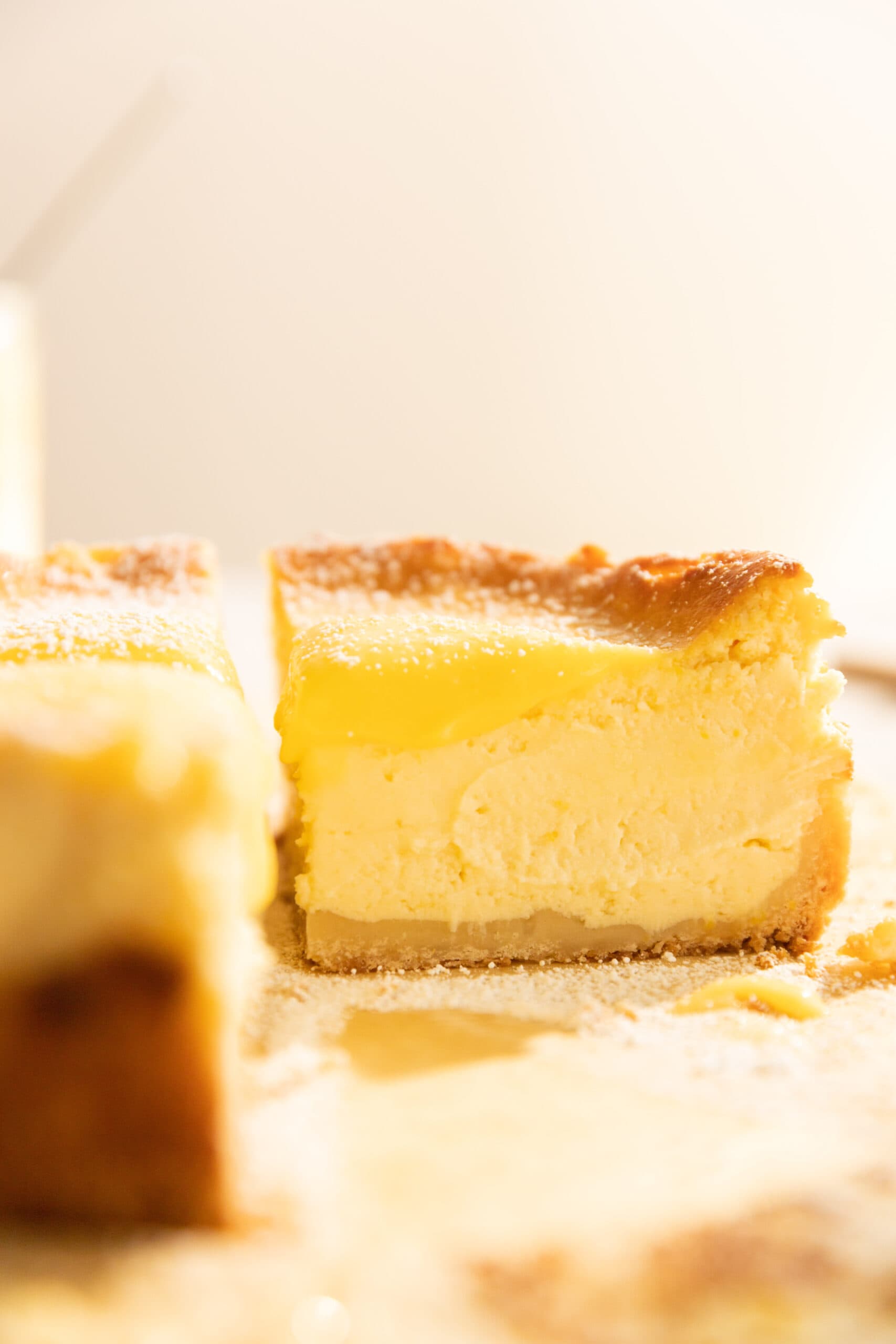 Side view of a quarter of a lemon baked cheesecake topped with lemon curd.