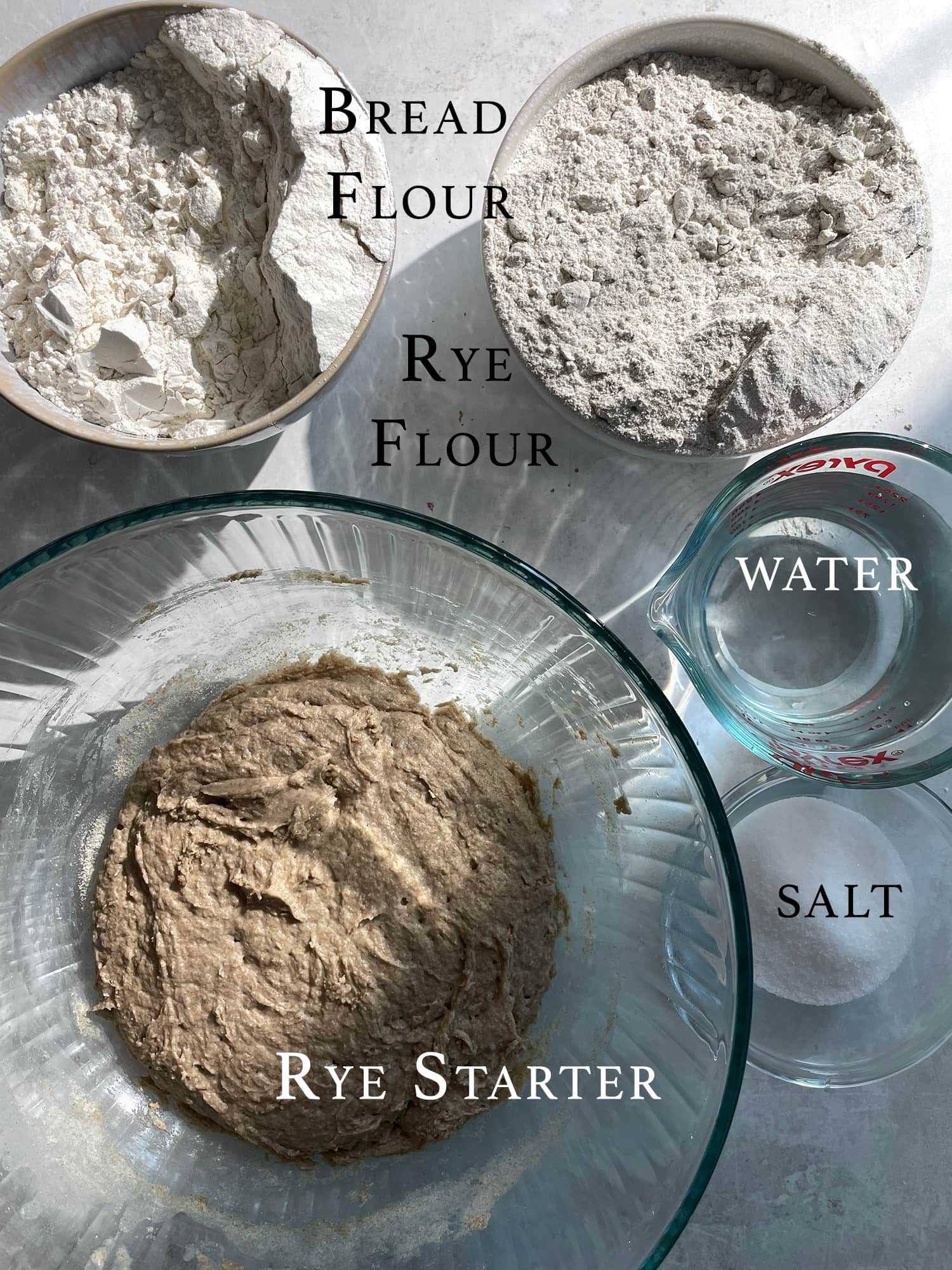Ingredients needed for rye sourdough listed out on a counter. 