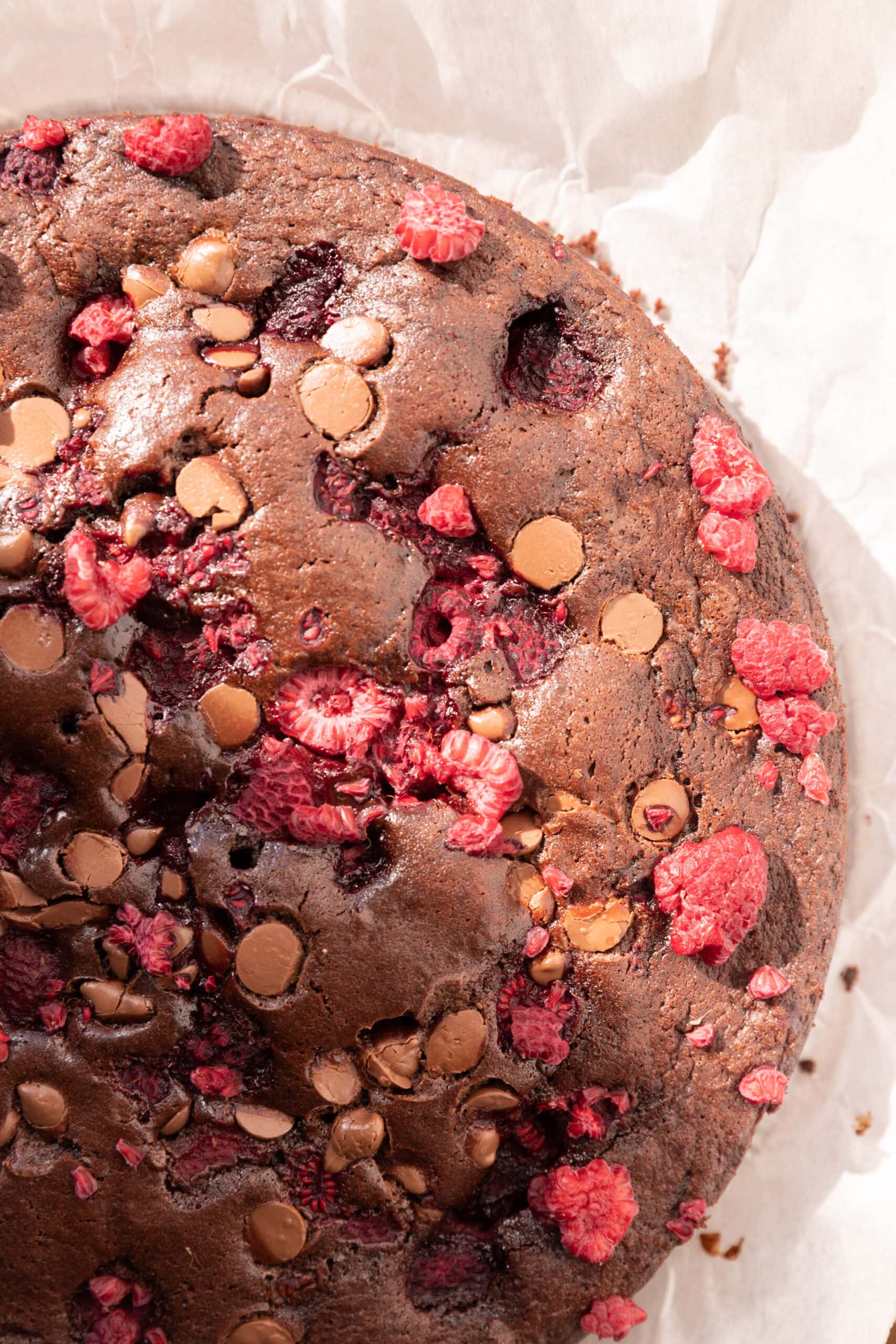 Overhead view of an easy raspberry chocolate cake with milk chocolate chips on top. 
