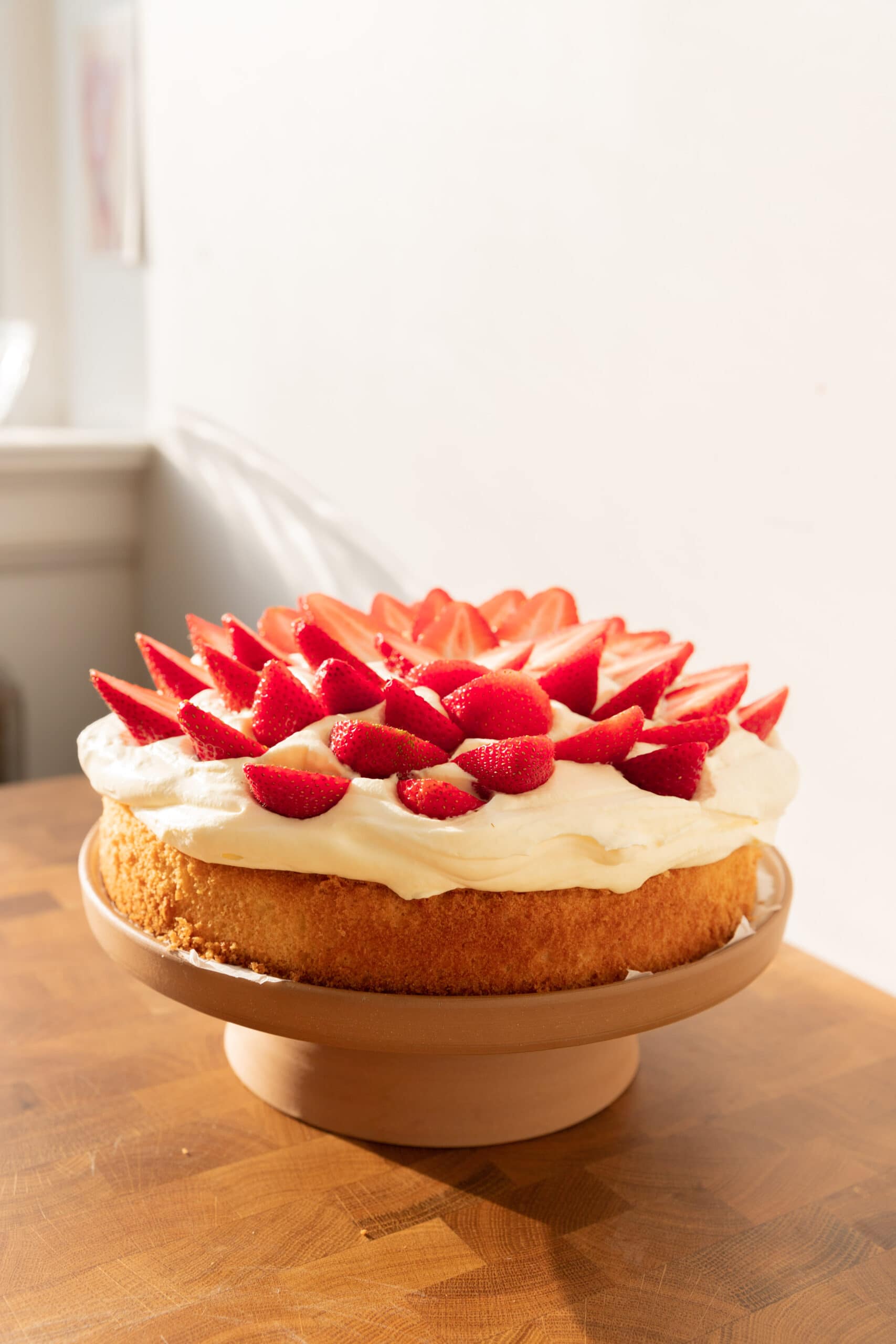 Strawberries & Cream Cake on a ceramic cake stand. 