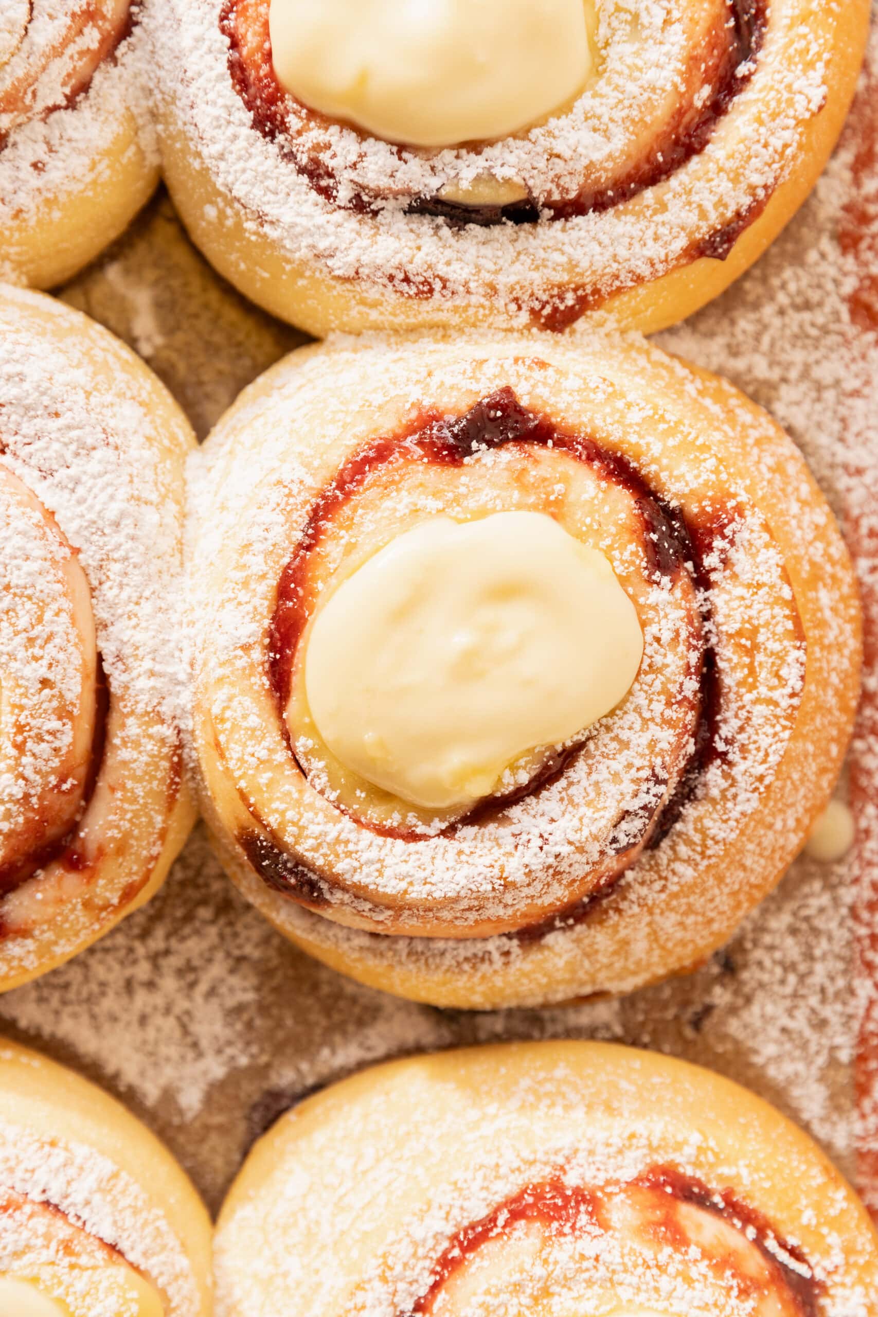 Overhead view of a pan of German plum rolls topped with a vanilla custard pudding. 