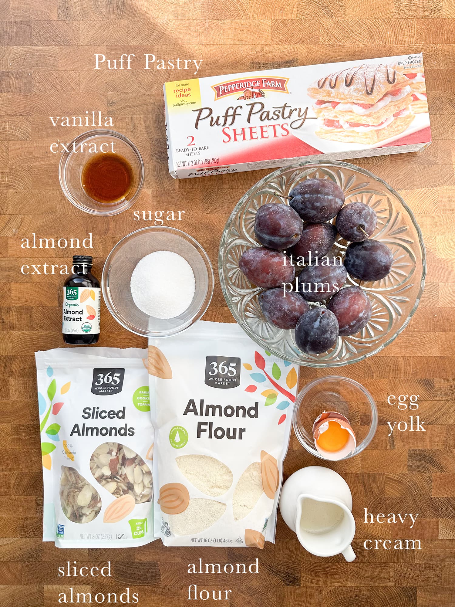 Ingredients needed to make puff pastry plum tarts laid out and labeled. 