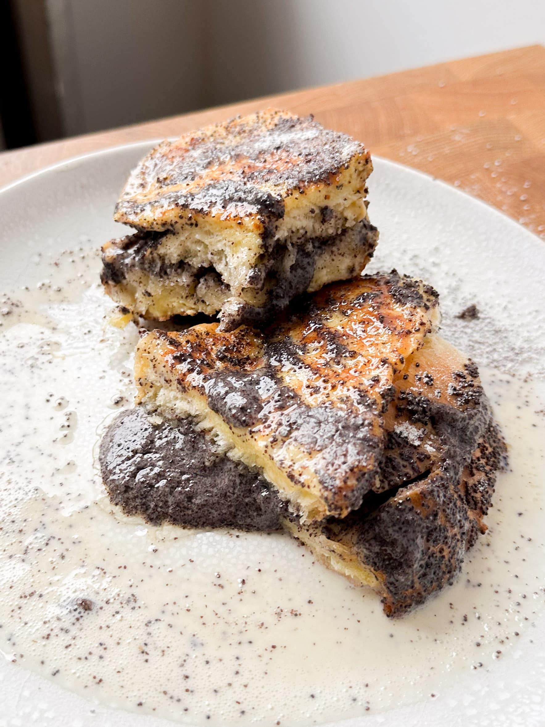 Poppyseed stuffed french toast cut in half on a white plate. 