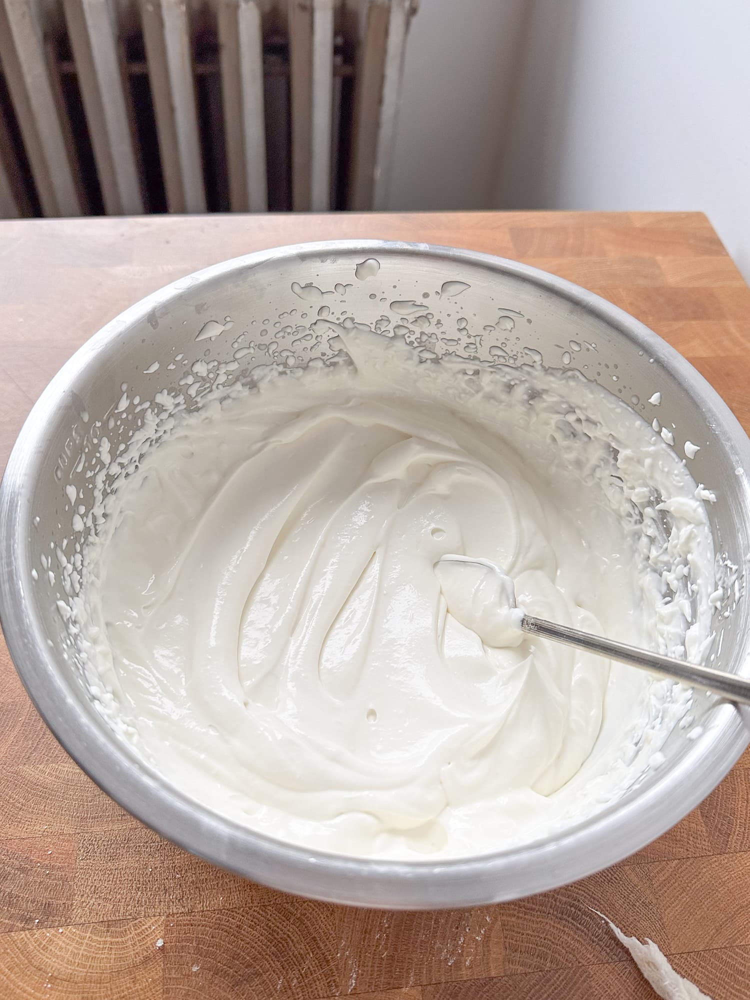 A metal bowl full of lemon yogurt whipped cream. 