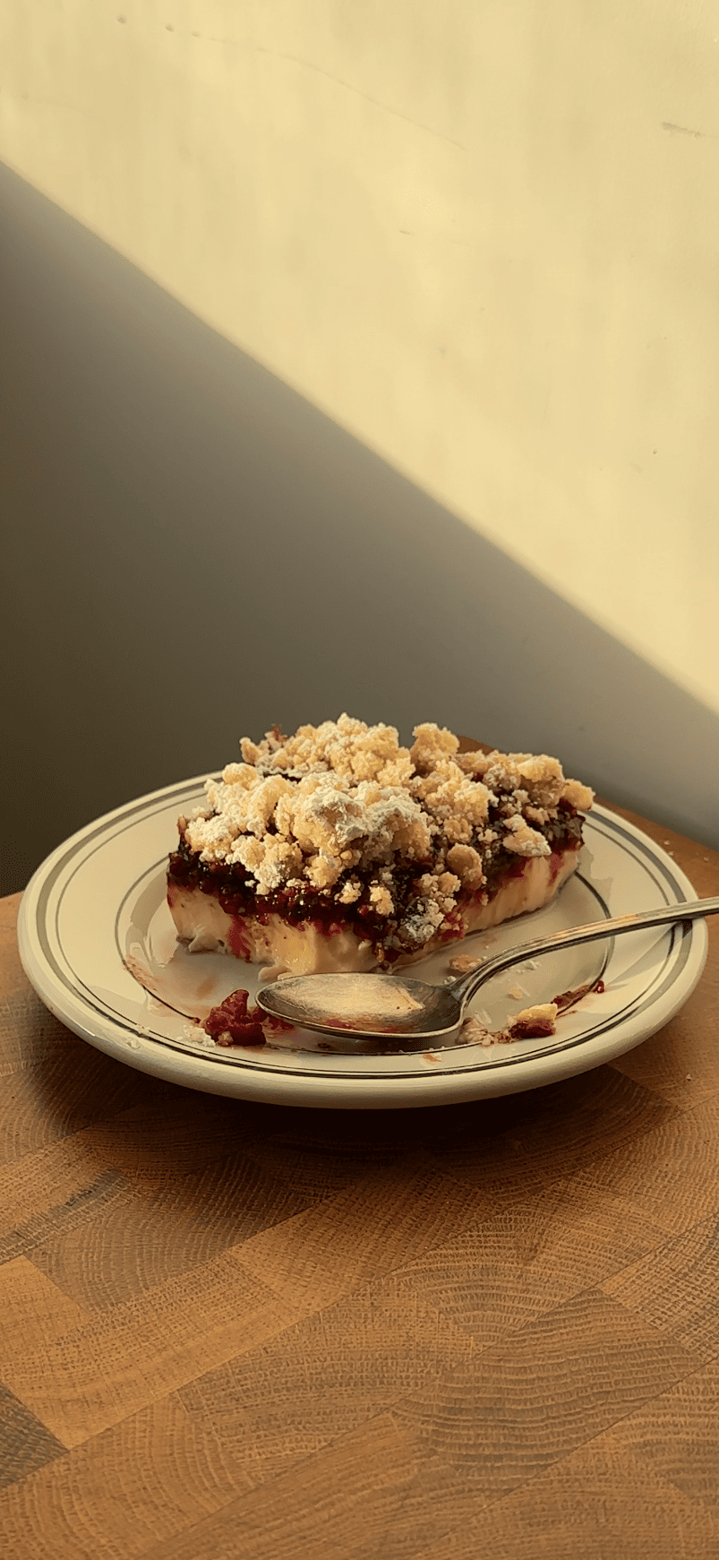 Slice of berry custard cake with a few bites taken out on a vintage plate.