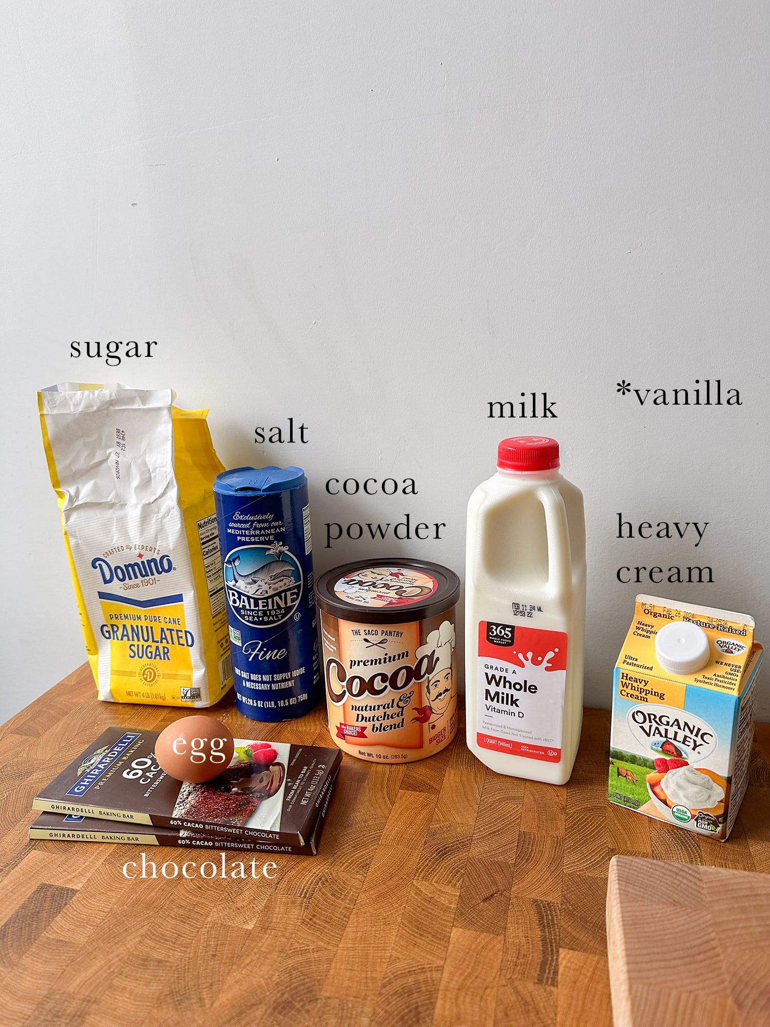 Ingredients needed to make dark chocolate mousse laid out and labeled on a kitchen island. 