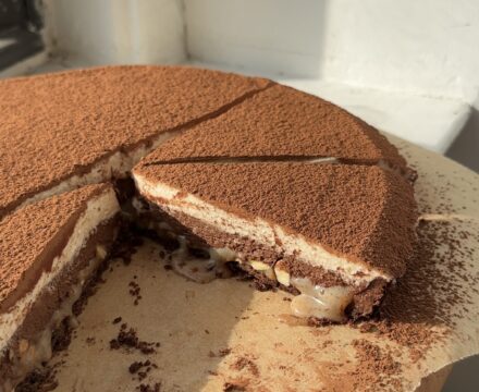 Side view of a chocolate hazelnut tart with slices cut out so the layers are visible.