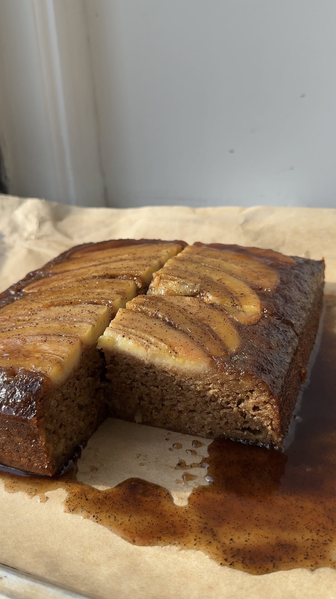 Side view of a banana upside down cake with a slice taken out.