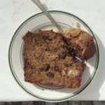 Overhead view of a slice of Chocolate chunk banana bread with a fork taking a bite out.