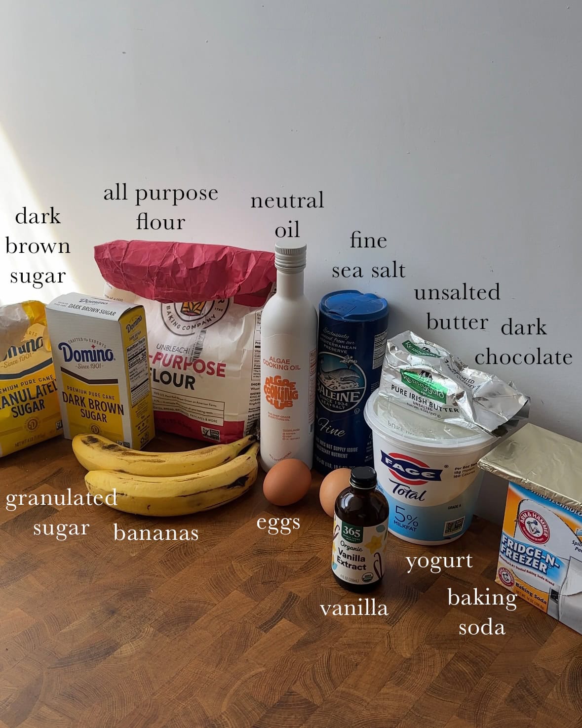 All ingredients needed for chocolate chunk banana bread laid out and labeled.