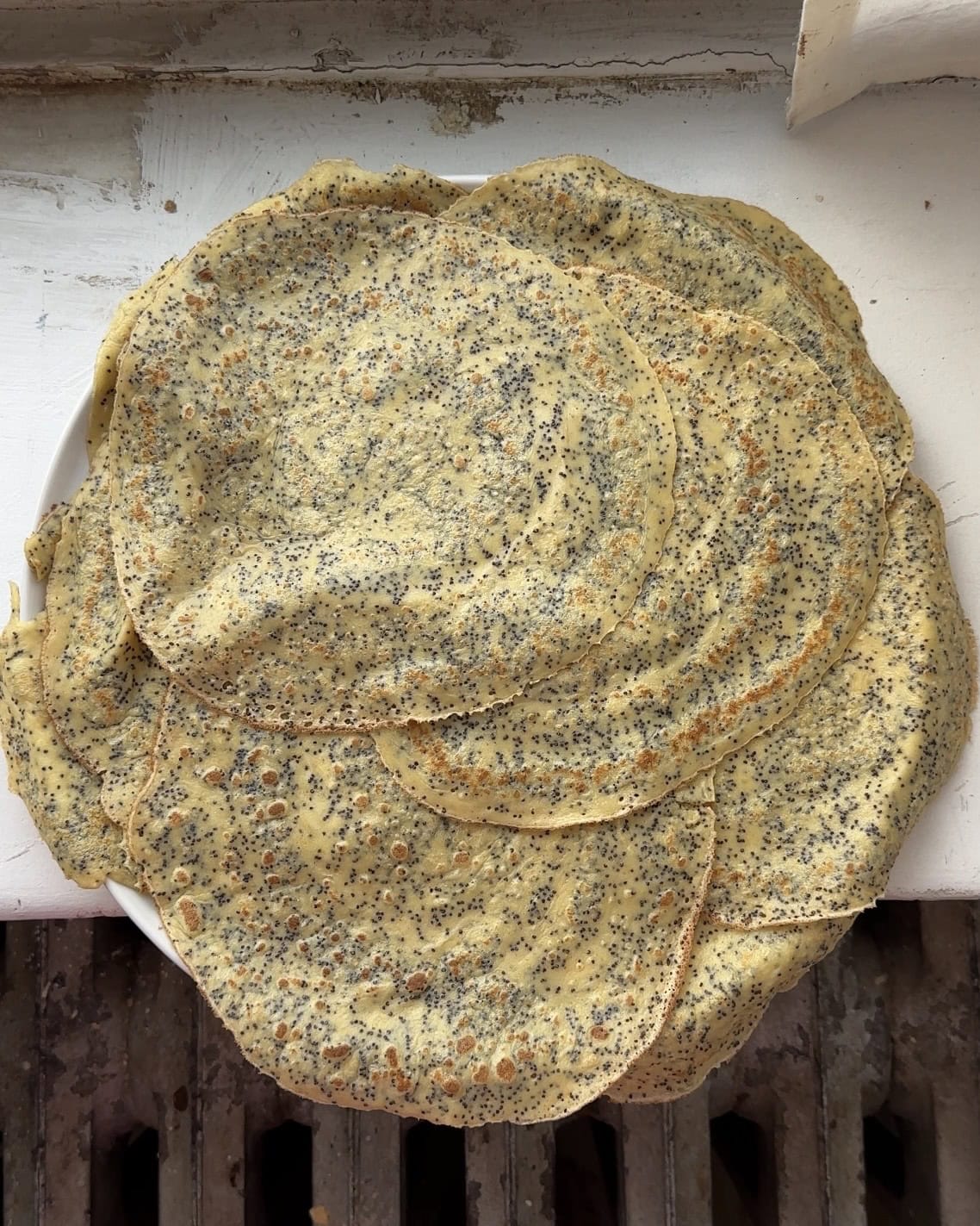 Overhead view of a plate full of lemon poppyseed crepes.