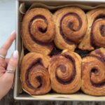 Overhead view of a pan full of flaky croissant cinnamon rolls.