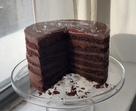 Side view of a 12 layer chocolate cake with slices taken out showcasing the 12 layers.