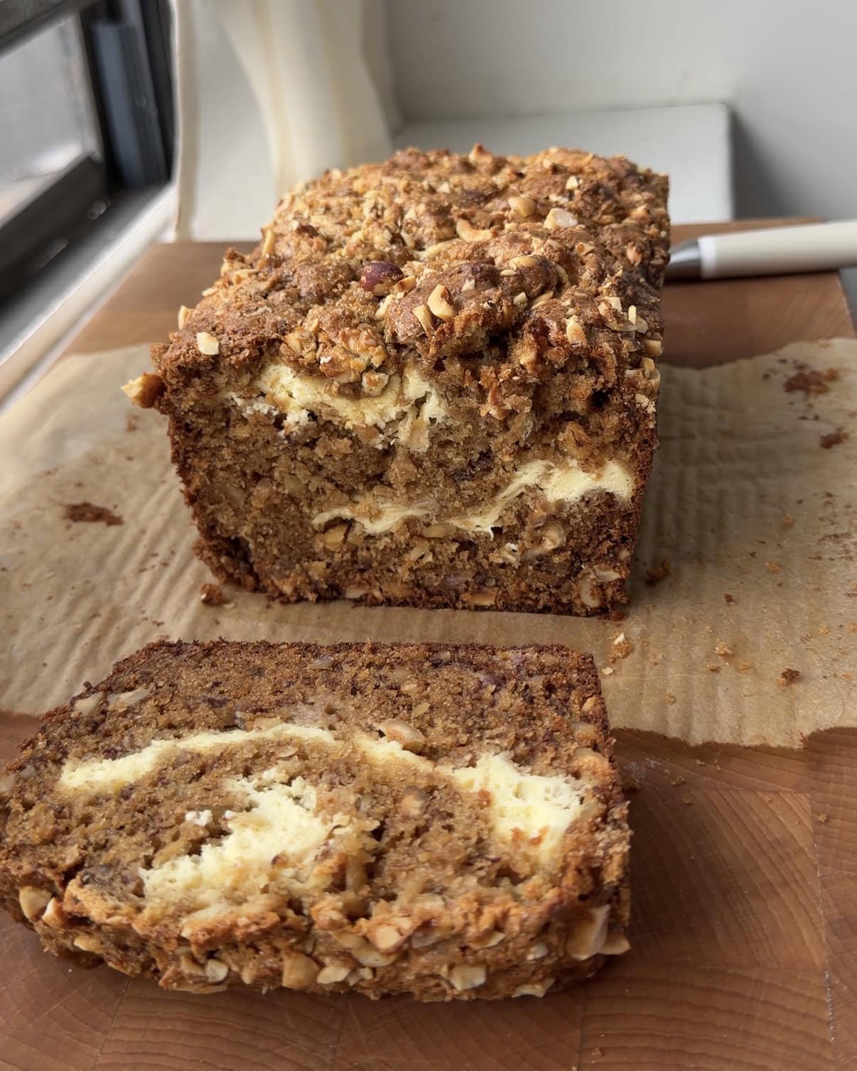 Side view of a Cream Cheese Walnut Banana Bread with slices cut showing the cream cheese swirl. 