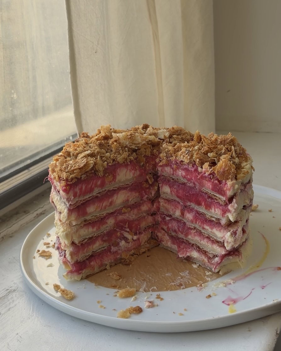 Side view of a Rhubarb napoleon cake with slices cut out showing off the layers.
