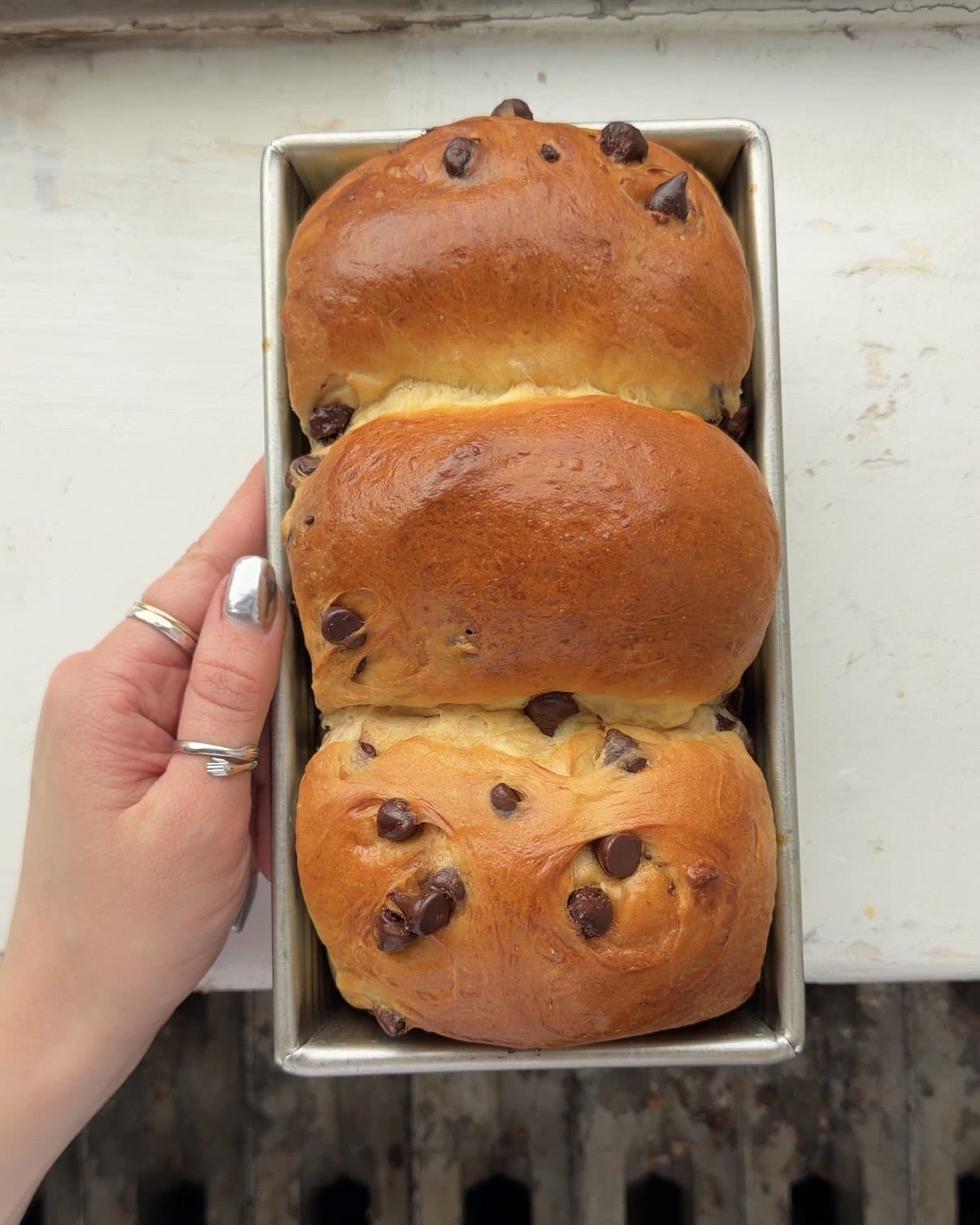 Overhead view of a Chocolate Chip Brioche Loaf in a metal loaf pan.