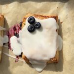 Overhead view of a lemon blueberry toaster strudel topped with a lemon glaze and fresh blueberries.
