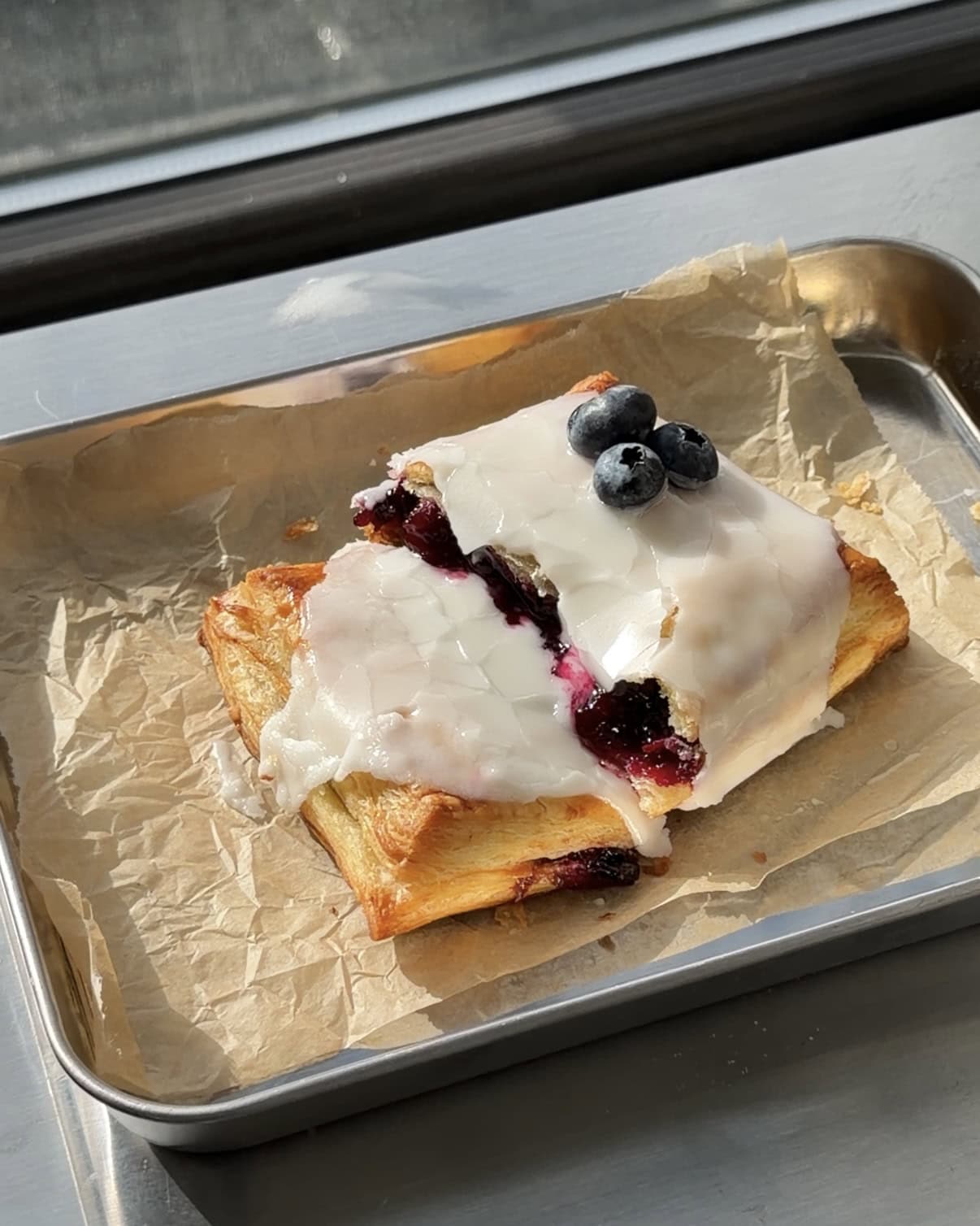 Side view of a Lemon blueberry toaster strudel torn in half showing the lemon blueberry filling.