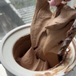 Image of an ice cream maker full of freshly churned chocolate ice cream.