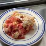 Side view of a blue and white plate topped with a rhubarb crumble.