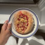 Overhead view of a sugar rolled Red Currant Brioche Bun topped with buttery streusel.