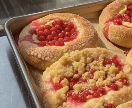 Side view of a baking sheet full of Red Currant Brioche Buns.
