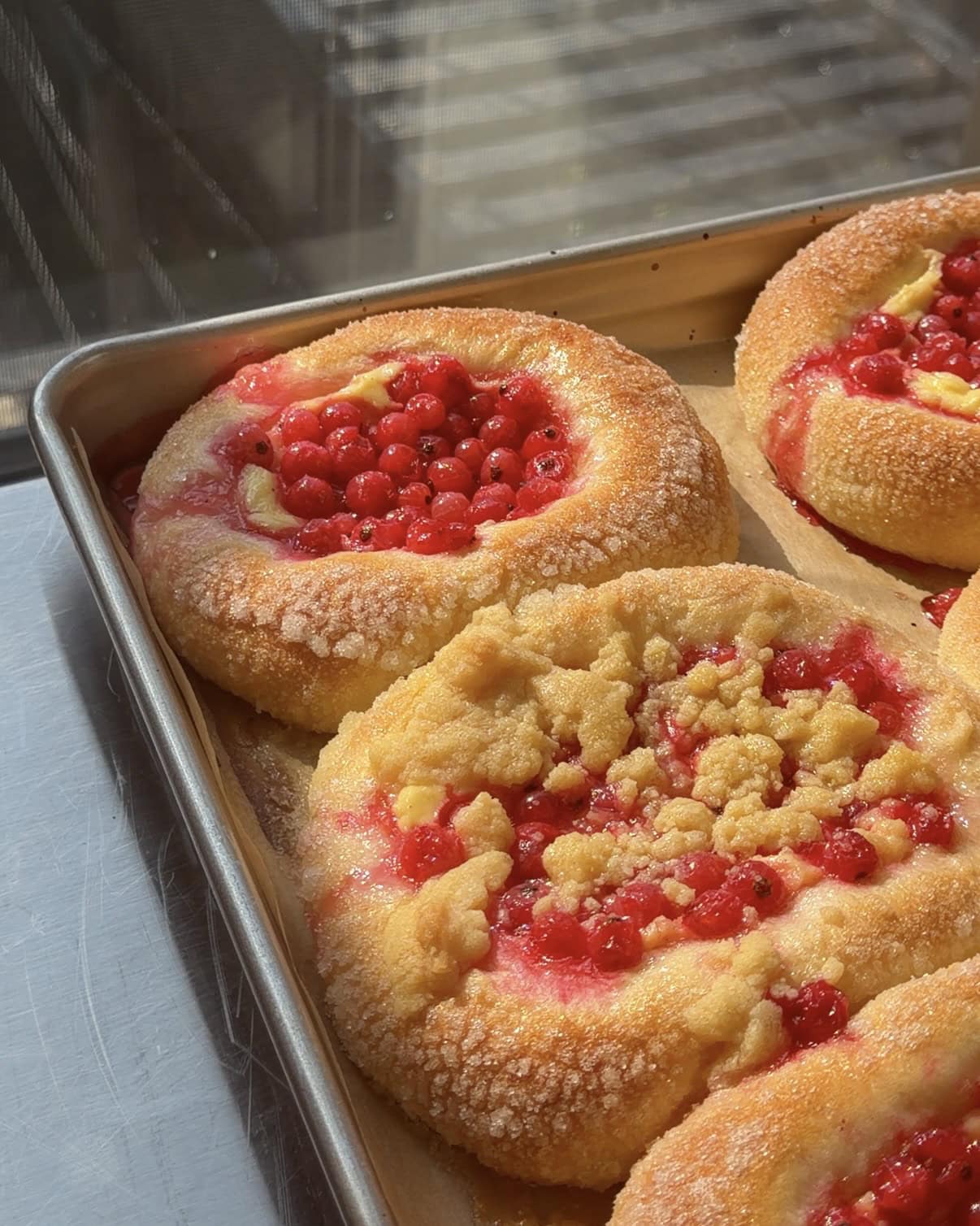 Side view of a baking sheet full of Red Currant Brioche Buns.