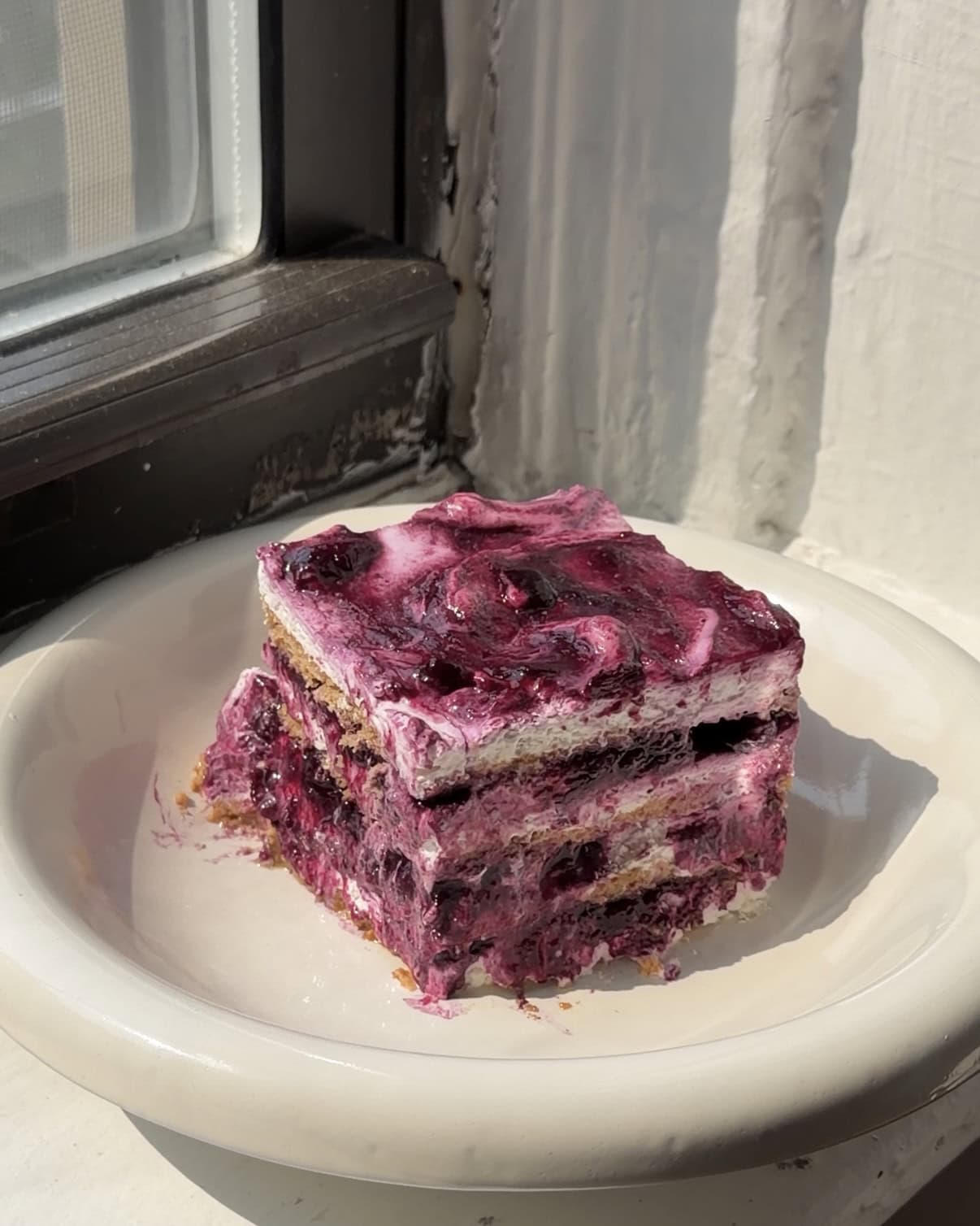 Side view of a slice of Lemon Blueberry Icebox Cake one a white plate.