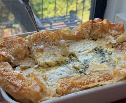 Side view of a baking dish full of Spanakopita Quiche.