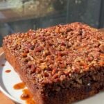 Side view of a Banana Bread Pecan Upside Down Cake on a white plate.
