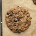 Overhead view of an Oatmeal Raisin cookie on a parchment lined baking sheet.
