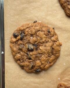 Overhead view of an Oatmeal Raisin cookie on a parchment lined baking sheet.